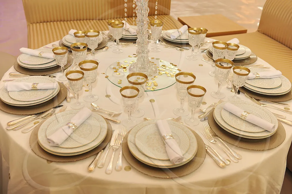Golden round table set with embroidered porcelain and crystal glassware, Rahal Maître Traiteur